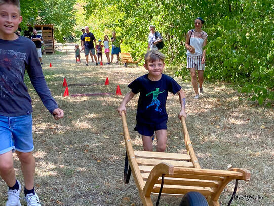 Die Brüder aus der Tiroler Straße feuern sich gegenseitig beim Schubkarren-Rennen an.